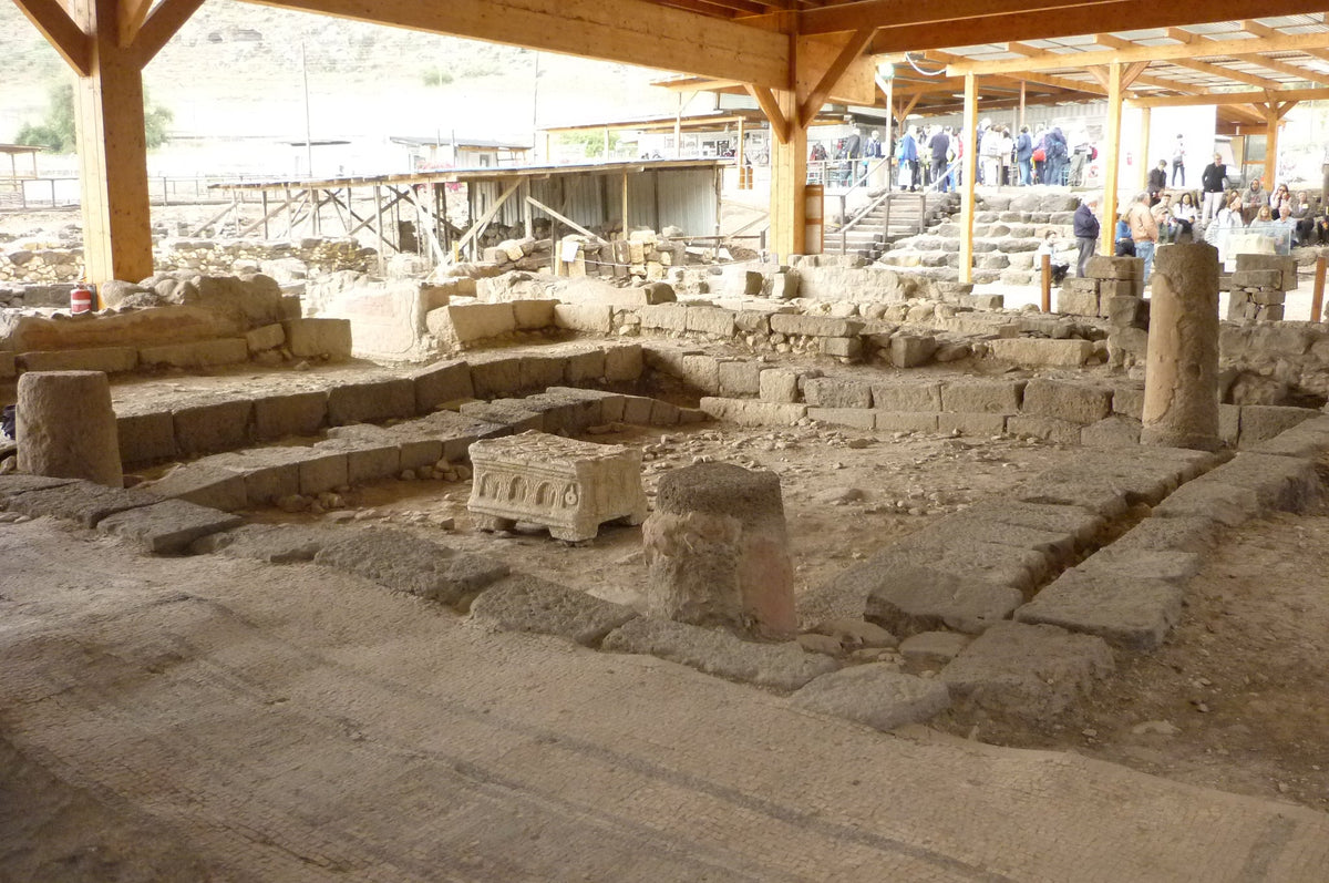 Excavated stone walls and seating of the ancient synagogue at Magdala beside the Sea of Galilee.